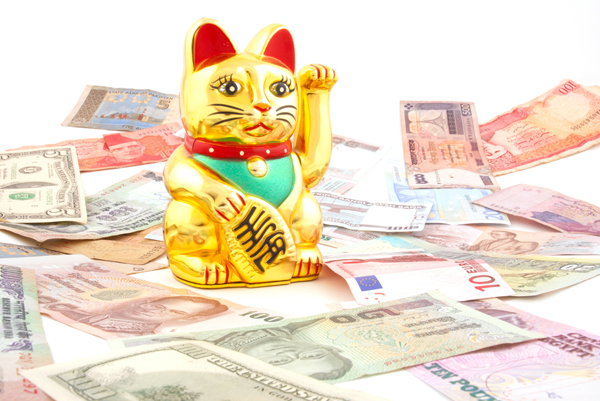 A Maneki Neko, or lucky cat, surrounded by money.