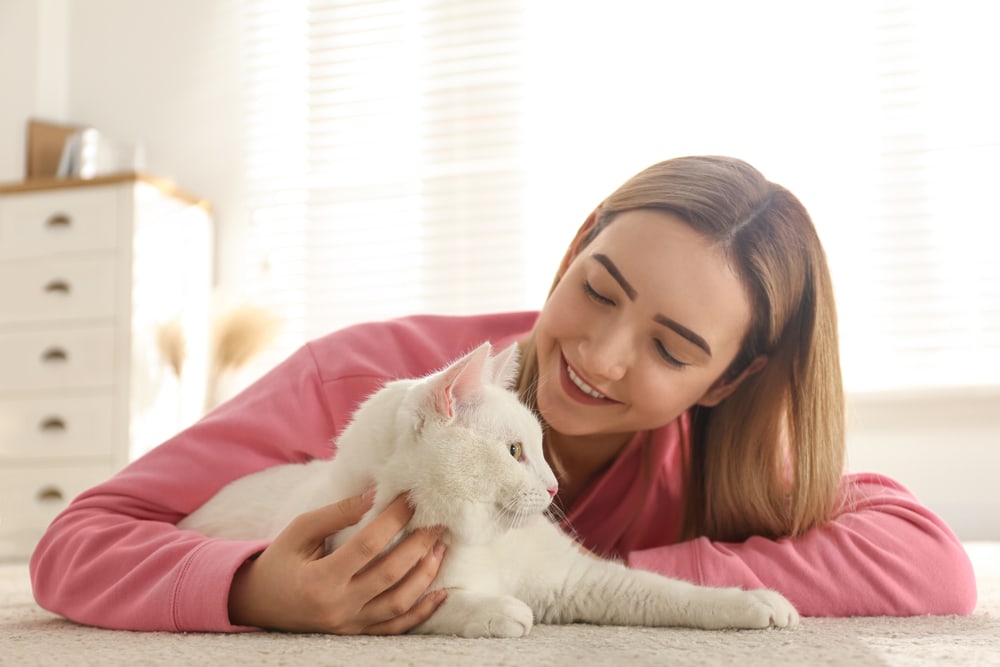 young woman owner with white cat